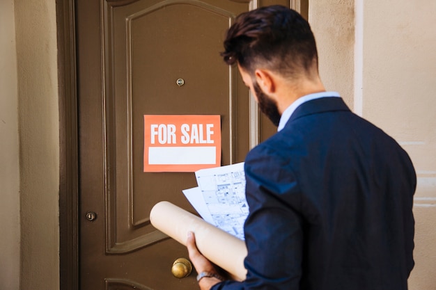 Foto gratuita agente inmobiliario en frente de una puerta