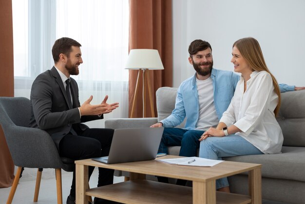 Agente inmobiliario masculino haciendo negocios y mostrando la casa a una posible pareja compradora