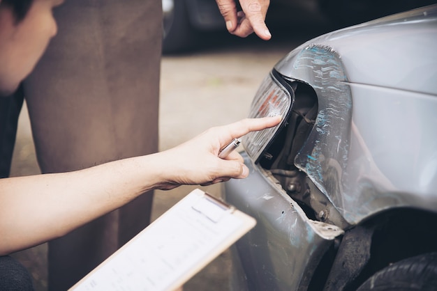 Foto gratuita agente de seguros que trabaja durante el proceso de reclamo de accidentes automovilísticos en el lugar, reclamo de seguro de personas y automóviles