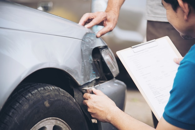 Agente de seguros que trabaja durante el proceso de reclamo de accidentes automovilísticos en el lugar, reclamo de seguro de personas y automóviles