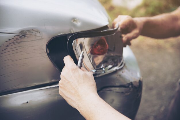 Agente de seguros que trabaja durante el proceso de reclamo de accidentes automovilísticos en el lugar, reclamo de seguro de personas y automóviles