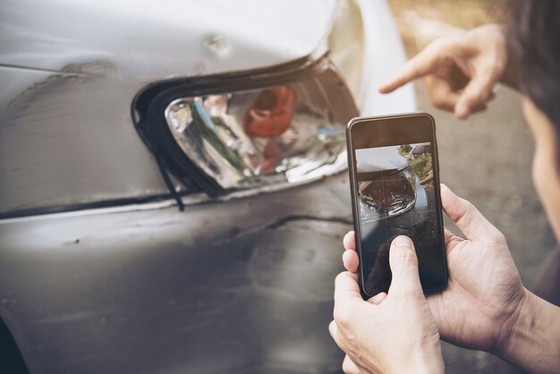 Agente de seguros que trabaja durante el proceso de reclamo de accidentes automovilísticos en el lugar, reclamo de seguro de personas y automóviles