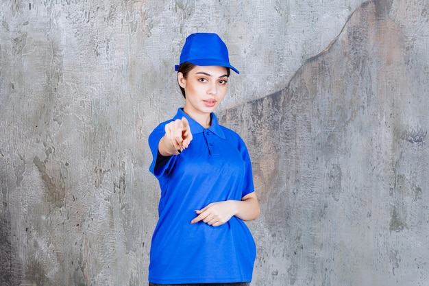 Foto gratuita agente de servicio femenino en uniforme azul que muestra a la persona que está delante.