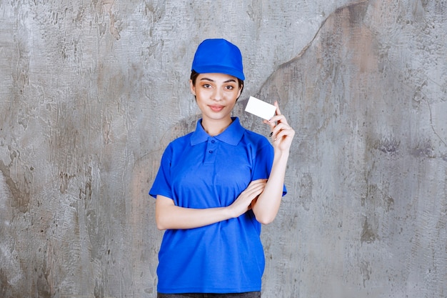 Agente de servicio femenino en uniforme azul que presenta su tarjeta de visita.