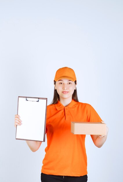 Agente de servicio femenino en uniforme de color naranja sosteniendo una caja de cartón y presentando una lista de verificación para su firma.