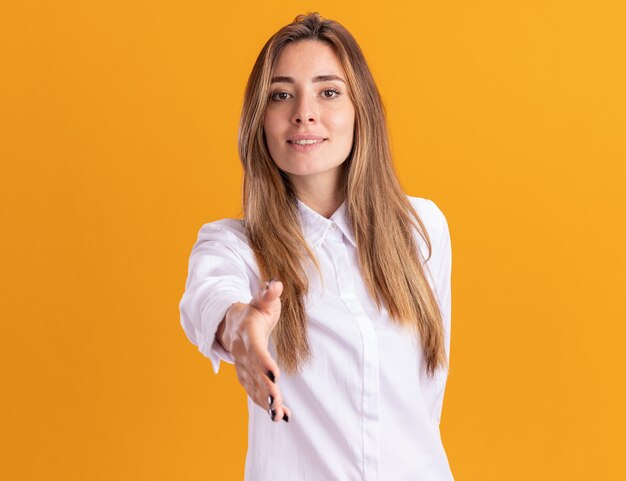 Agradable joven bastante caucásica sostiene la mano en naranja