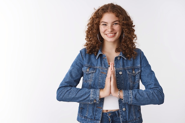 Agradecida joven encantadora feliz pelirroja niña agradeciendo inclinándose cortés prensa palmas juntas súplica orar gesto sonriendo ampliamente apreciar la ayuda, de pie fondo blanco encantado