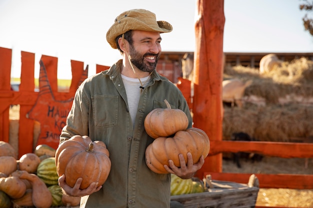 Agricultor con cosecha de calabaza en la granja