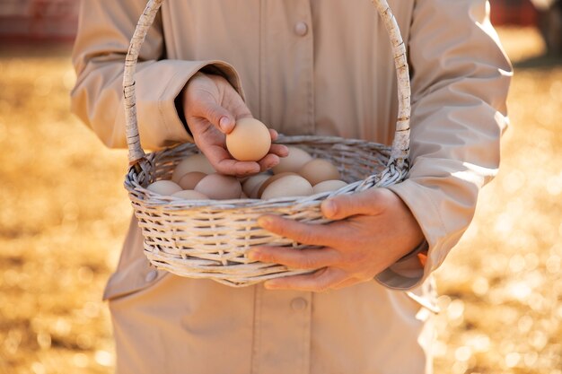 Agricultor sosteniendo la canasta con huevos de su granja