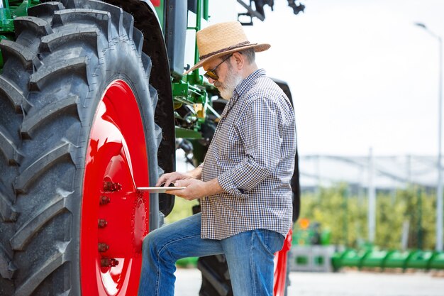 Un agricultor con un tractor, se combinan en un campo a la luz del sol.