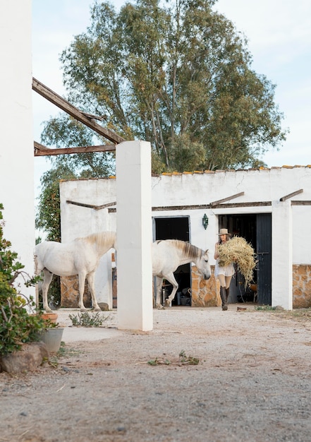 La agricultora llevando heno para sus caballos