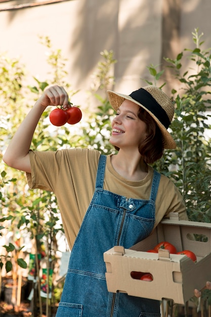 Foto gratuita la agricultora sosteniendo algunos tomates