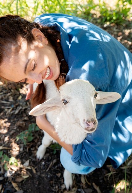 La agricultora sosteniendo una oveja bebé