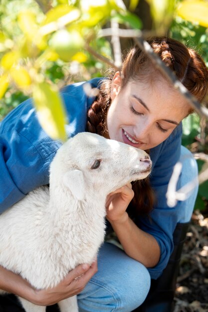 La agricultora sosteniendo una oveja bebé