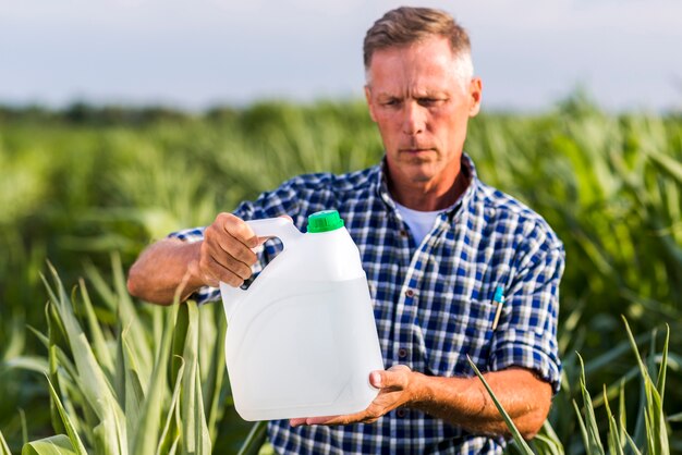 Agrónomo leyendo en una lata de insecticida