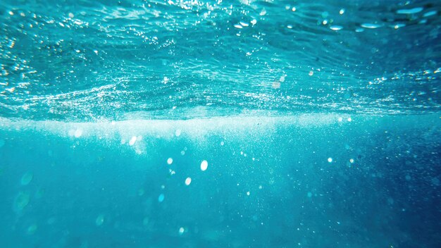 Agua azul y transparente del mar Mediterráneo. Luz solar, múltiples burbujas