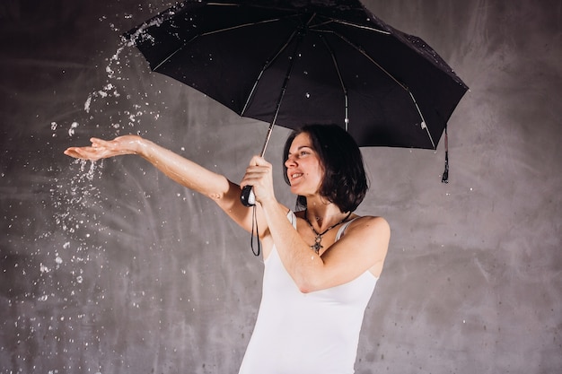 El agua cae sobre la mujer bajo el paraguas negro