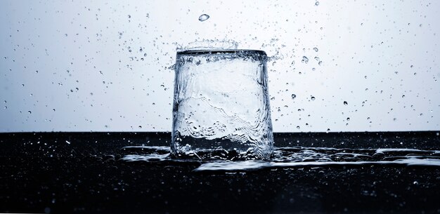 Agua clara en vaso con gotas de agua