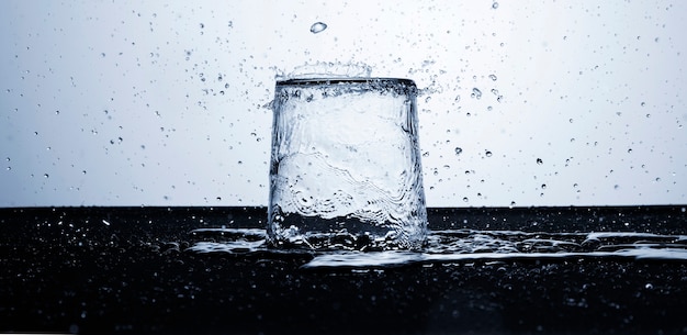 Agua clara en vaso con gotas de agua