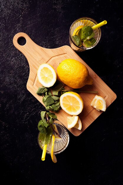 Agua de desintoxicación saludable y deliciosa con limones sobre fondo de madera vintage