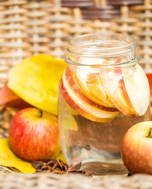 Agua detox con manzanas Composición otoñal con hojas y manzanas