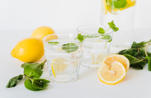 Agua de limón en vasos e ingredientes.