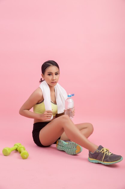 Agua potable hermosa joven apta del ajuste después del ejercicio