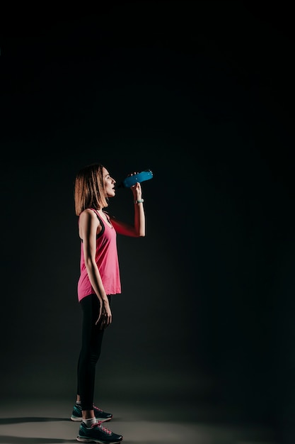 Agua potable de mujer deportiva en estudio