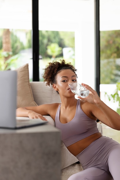 Foto gratuita agua potable de mujer deportiva de tiro medio