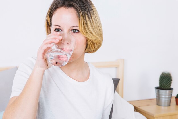 Agua potable de mujer en el dormitorio