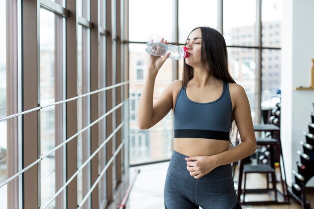 Agua potable de mujer en el gimnasio