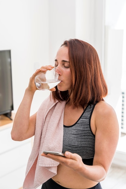 Foto gratuita agua potable de mujer de tiro medio