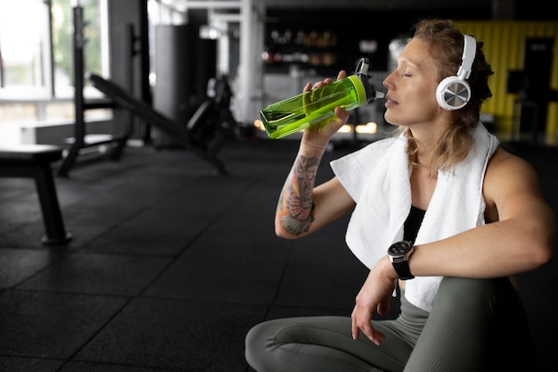 Foto gratuita agua potable de mujer de tiro medio