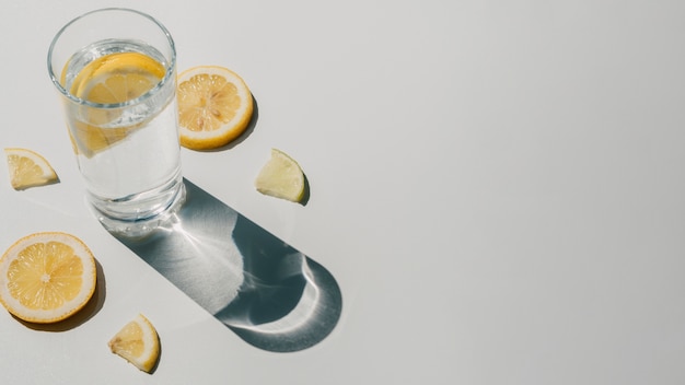 Agua con rodajas de limón y copia espacio de fondo