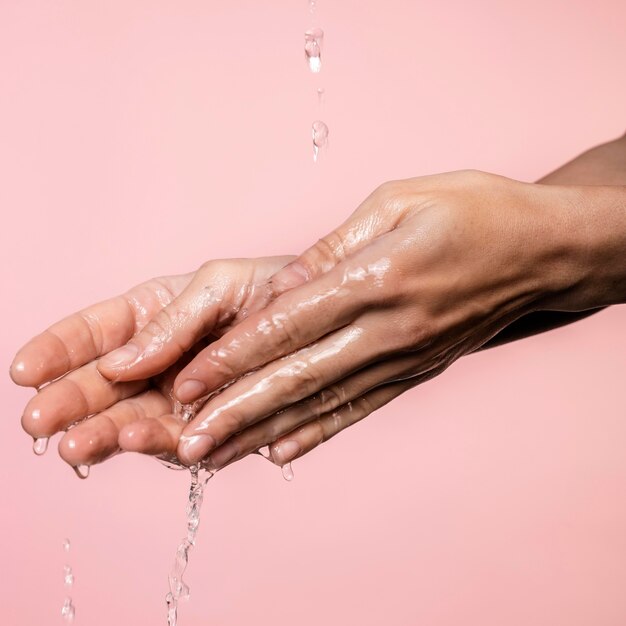 Agua vertida en manos de mujer