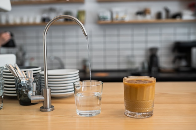 El agua se vierte de un grifo en un vaso