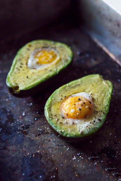 Aguacate a la mitad con yema de huevo en encimera de cocina