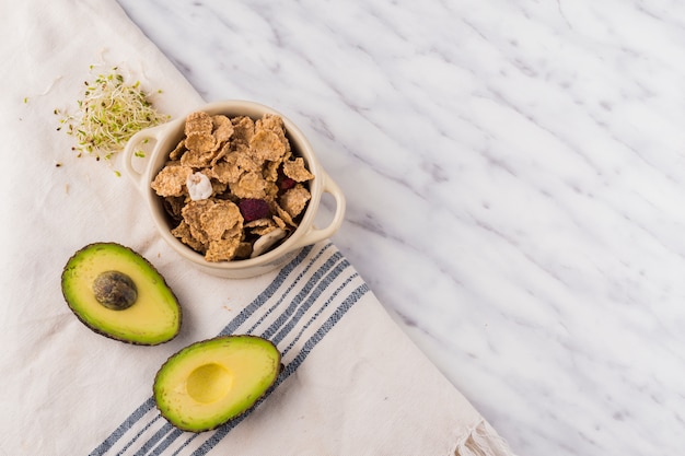 Aguacate verde con cereal en un tazón en mesa