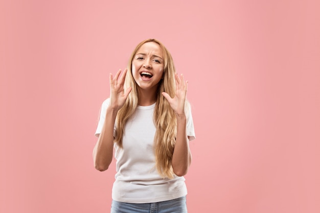 Aislado en rosa casual joven gritando en studio