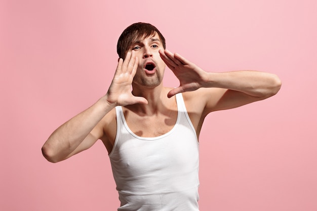 Foto gratuita aislado en rosa casual joven gritando en studio