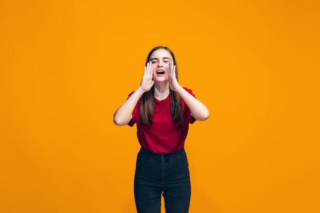 Aislado en rosa joven adolescente casual gritando en el estudio