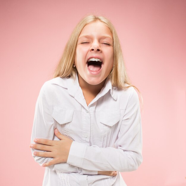 Aislado en rosa joven adolescente casual gritando en el estudio