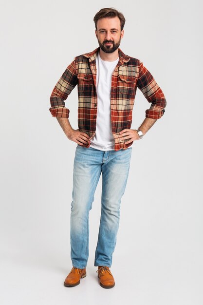 Aislado sonriente guapo barbudo en traje hipster vestido con jeans