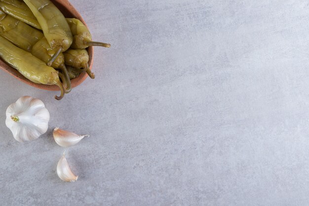 Ají en escabeche colocado sobre un fondo de piedra.