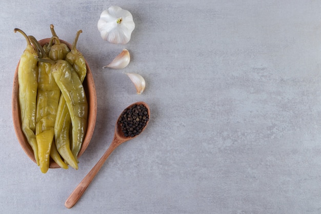 Ají en escabeche colocado sobre un fondo de piedra.