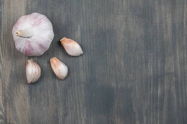 Ajo crudo con segmentos aislado en una mesa de madera