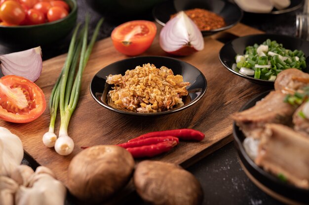 Ajo Frito en Plato Negro con Chili, Tomate y Shiitake.