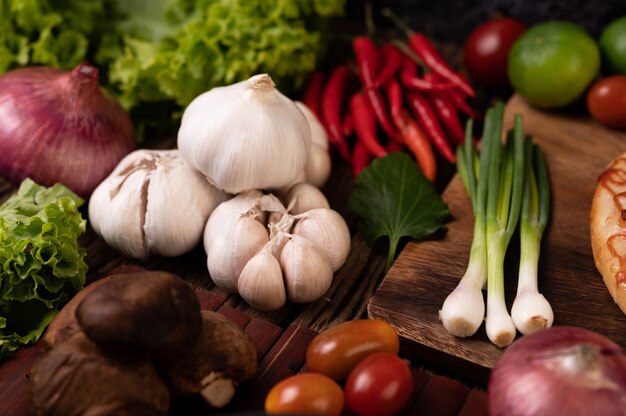 Ajo, tomate, seta shiitake, ají y cebolla morada sobre listones de madera