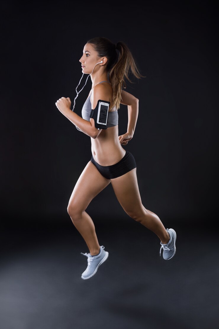 Foto gratuito ajuste y deportivo joven corriendo sobre fondo negro.