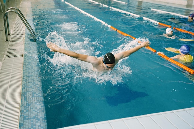 Ajuste el entrenamiento del nadador en la piscina. Nadador profesional masculino dentro de la piscina.